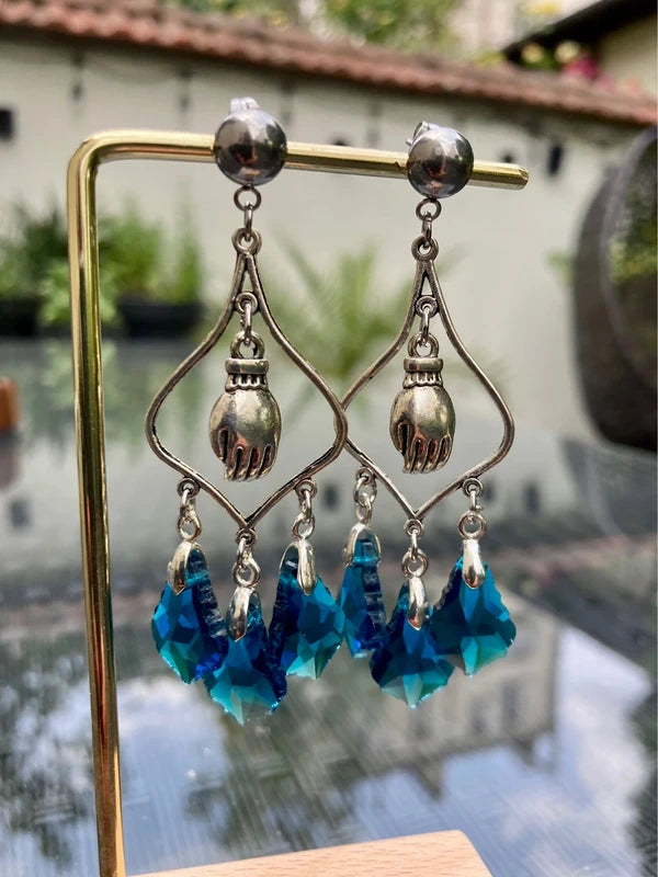 Boucles d’oreilles lustre main boudhiste acier inoxydable . Excellent état. Long 7 cm .