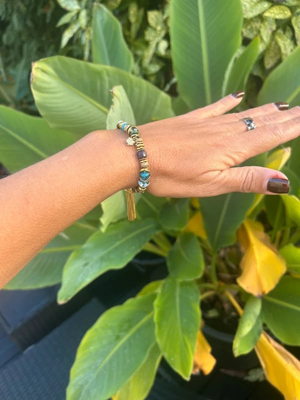 Bracelet élastique en pierre naturelles et acier inoxydable avec pompon excellent état.